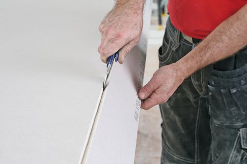 Sådan skæres gipsplader til: Skær derefter den anden kartonside igennem med hobbykniven. Sådan skæres gipsplader til: Skær derefter den anden kartonside igennem med hobbykniven.